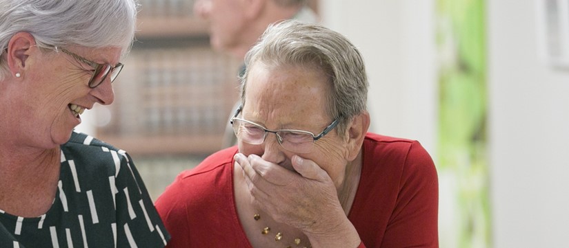 Bewoner en medewerker lachen
