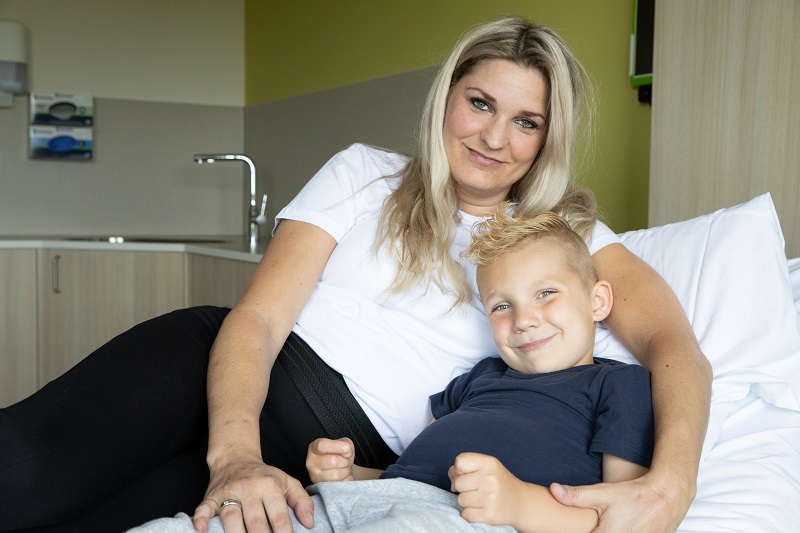 Op bezoek in het ziekenhuis moeder en kind in bed